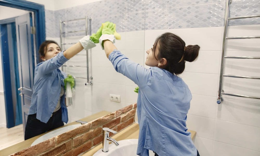 Woman with sponge and rubber gloves cleaning house